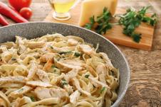 Alfredo pasta u tanjiru za pastu na stolu