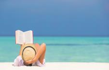 stockphotoyoungwomanreadingbookduringtropicalwhitebeach307112678.jpg