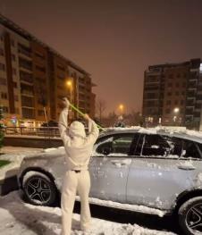 Stanija Dobrojević skida sneg sa automobila