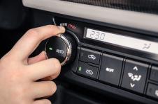 Muškarac podešava klimu u automobilu