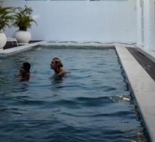 Dve devojke u bazenu na Baliju, iznenađene zbog prisustva nepoznatog gosta u vili