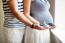 Buduća majka i otac drže bebine patike