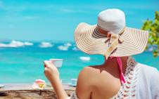Žena na moru na plaži pije kafu