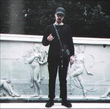 Šon Najt Nikolson skroz u crnom pozira ispred zida.jpg