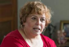 Starija žena u crvenoj majici i sa zlatnim naušnicama