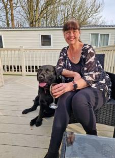 Šeron Pitketli pozira na terasi sa psom i časom vina u ruci.jpg