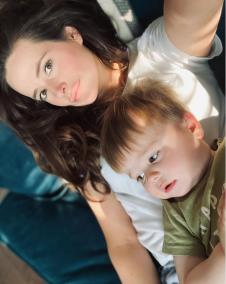 Bili Tompson sa mamom leži na krevetu.jpg