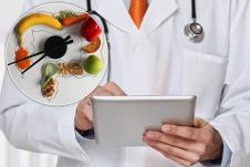 Doktor drži tablet/Maketa creva sa raspoređenom hranom