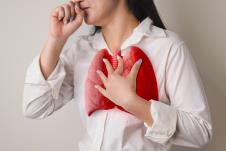 žena koja kašlje se drži za pluća koja su obeležena crvenom bojom