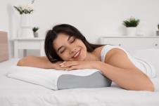 devojka leži na krevetu a glavu drži oslonjenu na jastuk