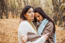 Majka i ćerka se grle u šumi punoj opalog lišća