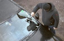 vozač čisti zaleđeno staklo na automobilu