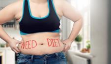 žena u topu se drži za salo oko struka na kome crvenim slovima piše Need diet