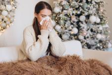 devojka sedi na kauču i duva nos