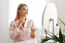 žena maže kremu na lice