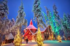 Božićno selo u Rovaniemiju sa drvenim kućicama, irvasima i svetlima na Arktičkom krugu, simbol prazničnog veselja i obnove grada