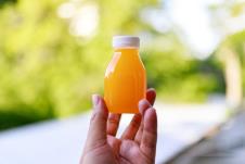 žena drži flašicu šota od pomoradže u ruci