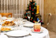 novogodišnja trpeza sa šampanjcem i čašama za šampanjac, jelka u pozadini