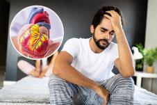 muškarac sa sedi na krevetu i hvata se za glavu, koncept erektilna disfunkcija/srce
