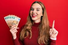 srećna žena drži evre u rukama