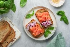 tost sa filetima dimljenog losossa i crvenim lukom serviran uz uz svež bosiljak