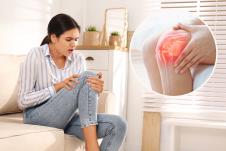 mlađa devojka u farmerkama i košulji drži sa obe ruke desno koleno/bol uzglobu kolena