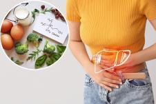 devojka u žutoj majici se drži za stomak u predelu jetre/namirnice bogate holinom (vitamin B4)