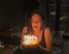 Maša Memedović nasmejana dok duva svećice na rođendanskoj torti (1).PNG