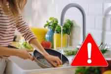 žena pere tiganj, crveni trougao sa znakom uzvika