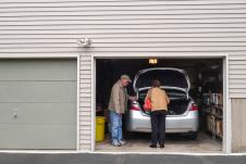 Deka i baka vade stvari iz prtljaga auta u garaži