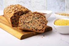 domaći hleb od kinoe sa semenkama na drvenom pladnju, sastojci u činijama na stolu