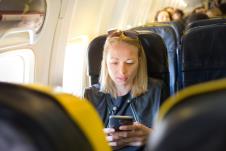 žena u avionu pali avionski režim na telefonu