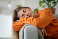 umorna žena u perimenopauzi drema na kauču