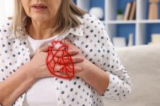 starija žena se drži za grudi u predelu srca koje je obeleženo crvenom bojom, bol u grudima