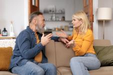 bračni partneri u srednjim godinama u raspravi na kauču