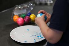 Dečak ljušti ofarbana jaja za Uskrs kako bi ih pojeo