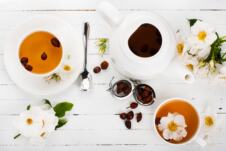 čaj od šipurka serviran u dve šoljice uz čajnik i sveže svetove šipurka