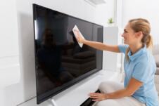 Žena briše prašinu sa tv ekrana