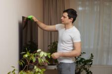 Muškarac briše prašinu sa televizora