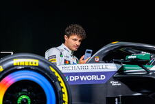 Lando Noris pored bolida Meklarena u belim bojama za trku u Silverstonu