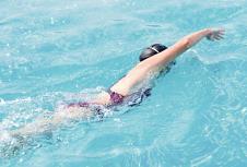 stockphotoyounggirlingogglesandcapswimmingfrontcrawlstrokestyleinthebluewaterpool257784676.jpg