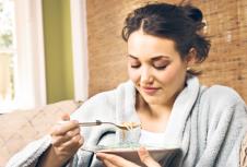 stockphotoyoungwomansittingonacouchinabathrobeeatingsoupverticalshot45005488.jpg