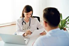 stockphotoseriouswomandoctorinpharmacyreadingmedicalprescriptiontopatient659604607.jpg