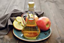 stockphotoapplecidervinegaringlassbottleandfreshapplesonwoodenbackground220256785.jpg