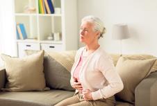 stockphotooldagehealthproblemandpeopleconceptseniorwomansufferingfromstomachacheathome711572713.jpg