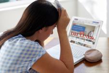 žena se drži za glavu, laptop