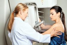 stockphotomaturefemaledoctorassistingyoungpatientundergoingmammogram130569779.jpg