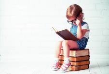 stockphotohappychildlittlegirlwithglassesreadingabooks365175962.jpg