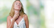 stockphotobeautifulyoungwomanoverisolatedbackgroundtouchingpainfulnecksorethroatforfluclodand1311202862.jpg