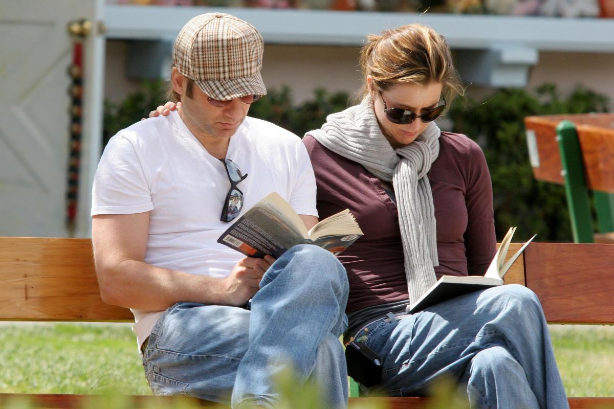 Tea Leoni i Dejvid Duhovni čitaju knjige u parku na klupi